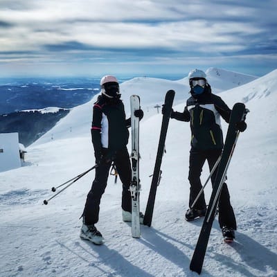 Un couple fait du ski dans les Alpes