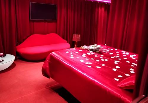 L'Hacienda La Demeure chambre rouge La Séductrice lit avec miroir décoration romantique et fauteuil en forme de bouche