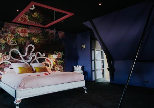 La chambre rose avec son miroir au plafond et la balançoire de l'amour