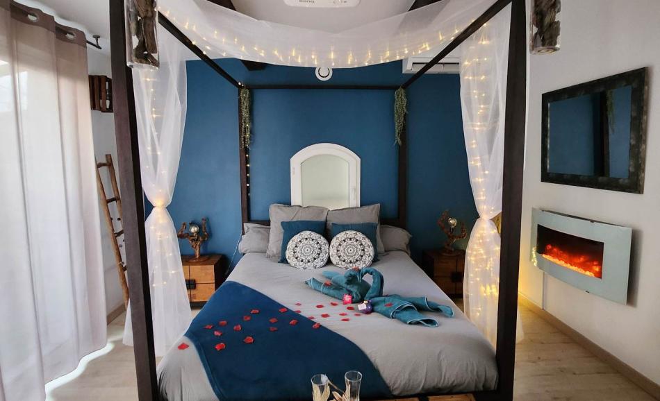 L'Orée des pins chambre bleu nuit avec cheminée électrique et lit à baldaquin ambiance romantique