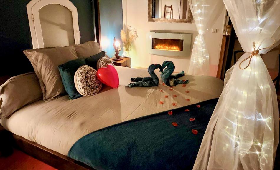 L'Orée des pins chambre bleu nuit avec cheminée électrique et lit à baldaquin ambiance romantique
