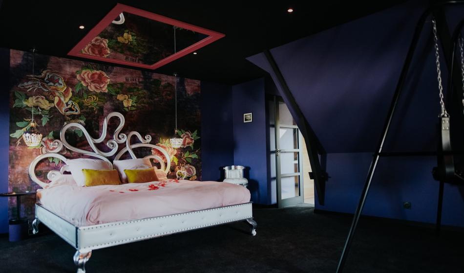 La chambre rose avec son miroir au plafond et la balançoire de l'amour